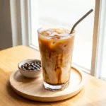 iced oolong milk tea in clear glass with ice and brown sugar swirl