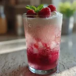 Raspberry vanilla dirty soda in a glass with cream and raspberry syrup