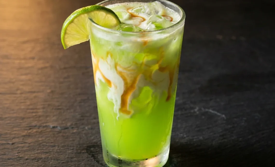 finished mountain dew dirty soda with cream ribbon and lime garnish