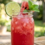 watermelon agua fresca recipe in a mason jar with lime wheel and fresh mint