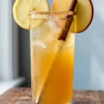 apple cider mocktail recipe in a collins glass with cinnamon sugar rim