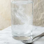 Glass of salt water flush recipe with salt dissolving