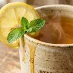 Starbucks medicine ball tea in a ceramic mug with lemon and mint