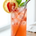 Strawberry lemonade recipe in a glass with lemon and mint garnish